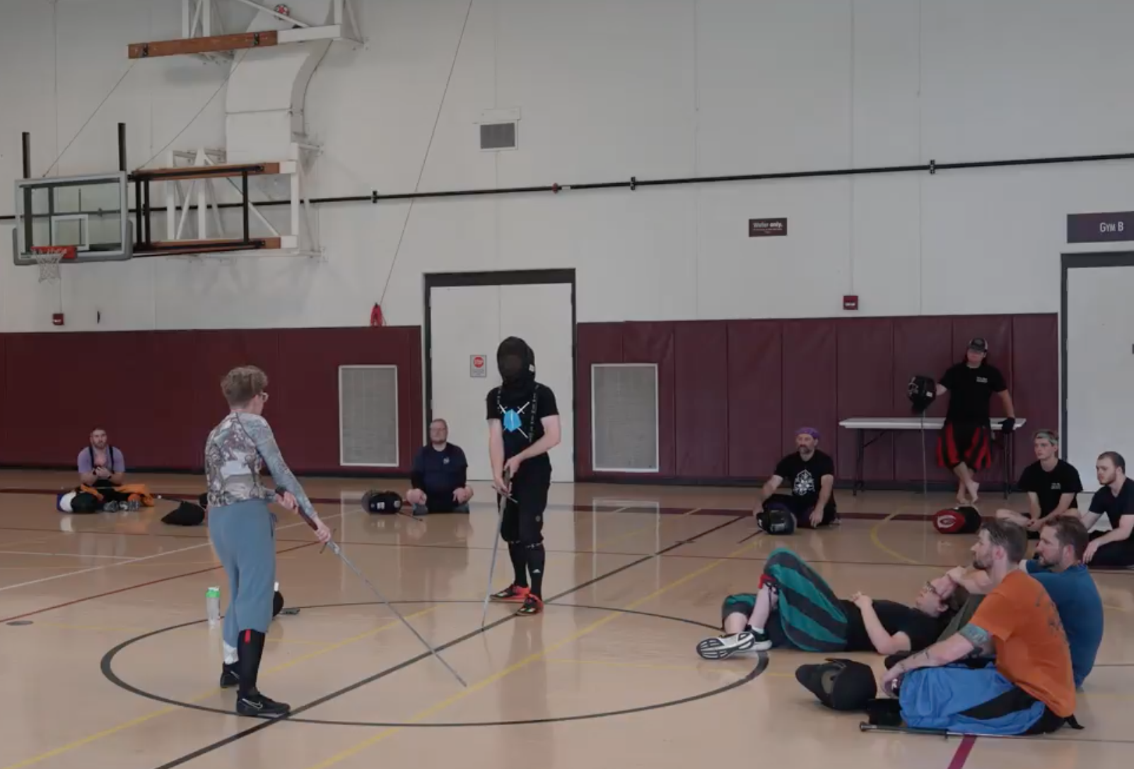 A photo of a guest instructor from last year teaching a workshop. The instructor assistant and the instructor are demonstrating to a group of attendees.
